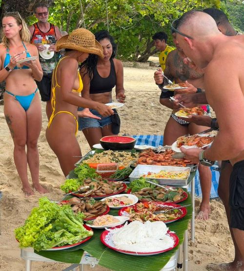 Guests enjoying a beach lunch spread
